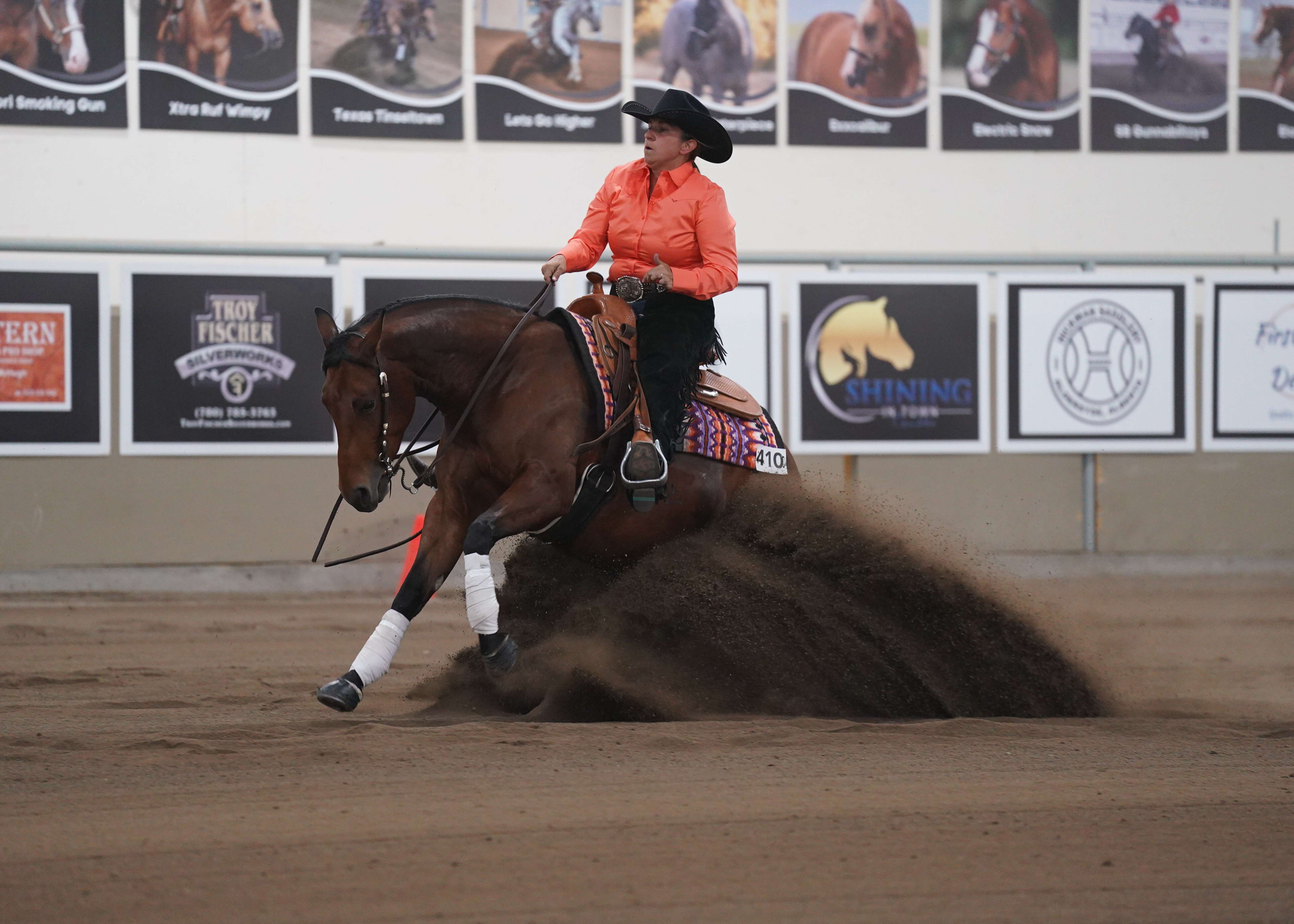 A reining horse and rider competing in the arena